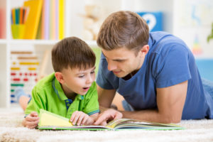 young boy and manny read book together