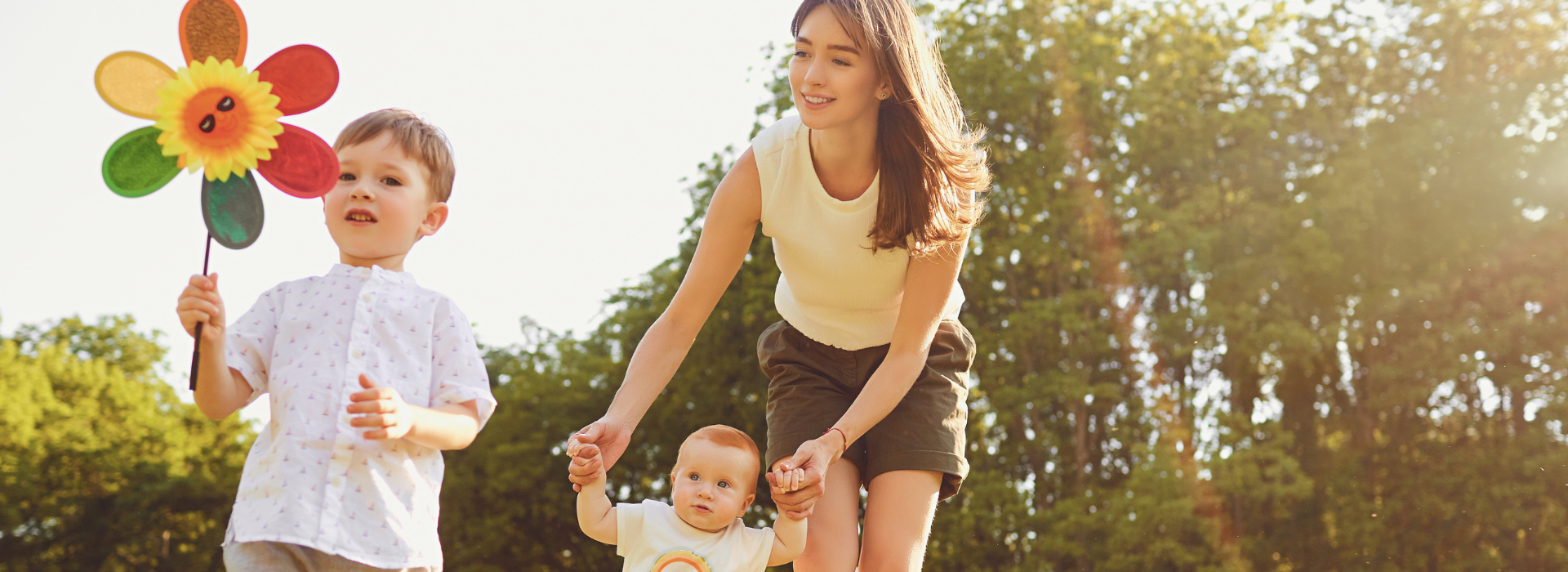 Nanny and two kids playing in a park