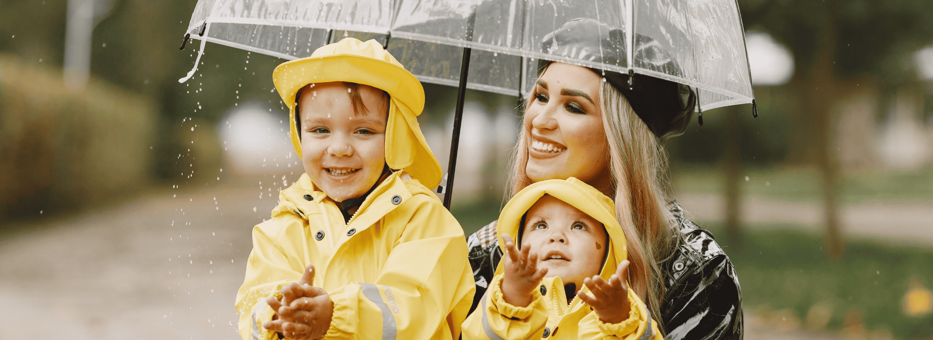 nanny and kids in yellow rain suits playing in the rain