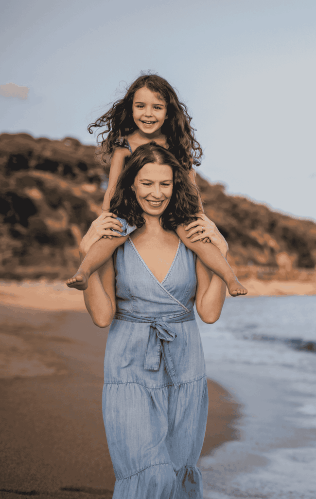 Nanny and child walking down a beach