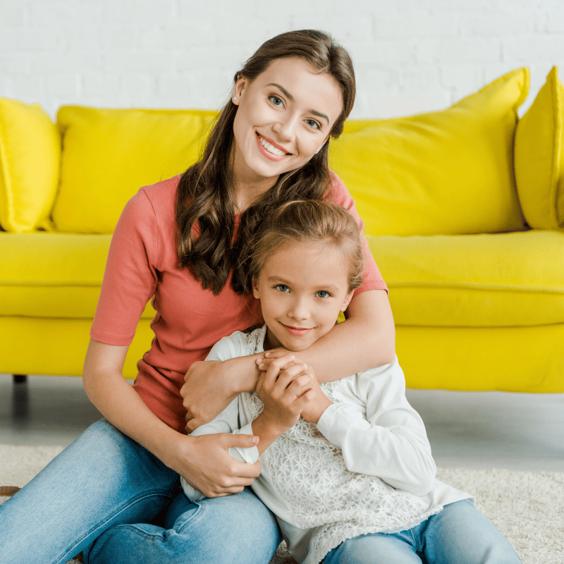 Nanny and child sitting on the floor smiling