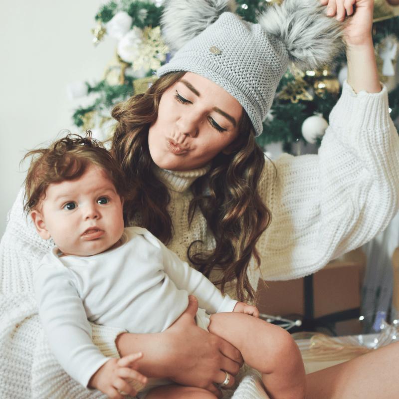 Nanny and child in front of a Christmas tree