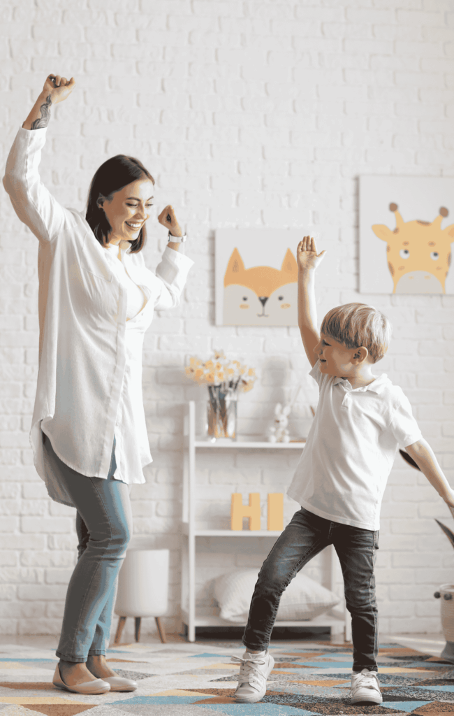 Nanny and child dancing in a playroom