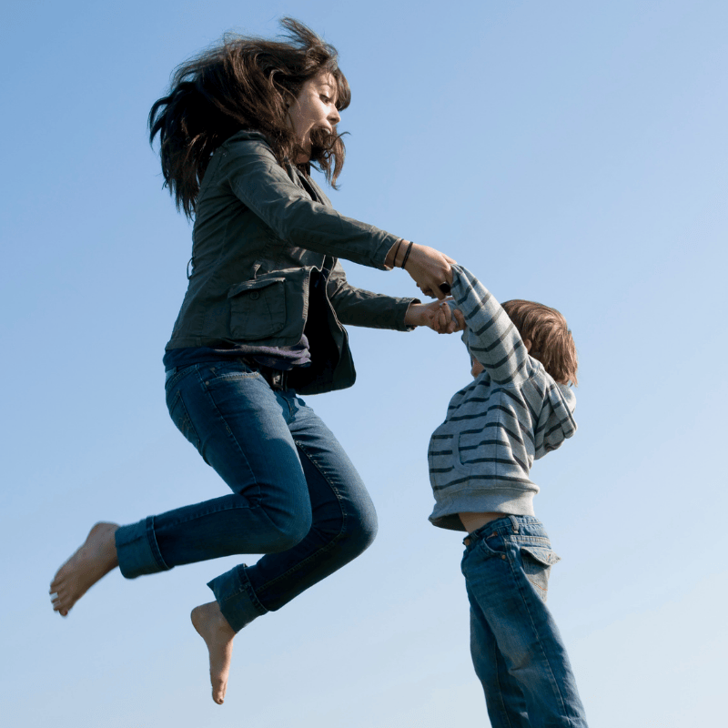 Nanny and child jumping into the air