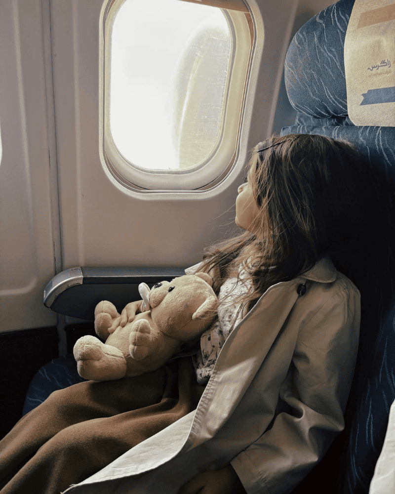 Young girls sitting in the window seat on a plane