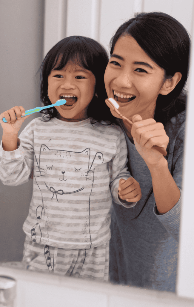 Child and nanny brushing their teeth