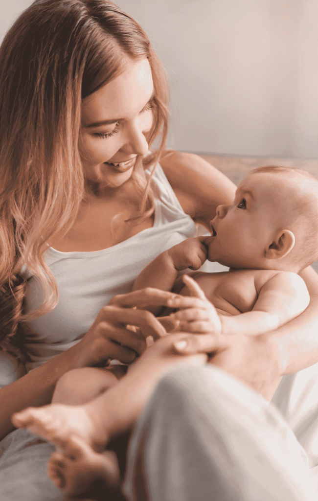 Newborn lying in his moms arms while staring at her