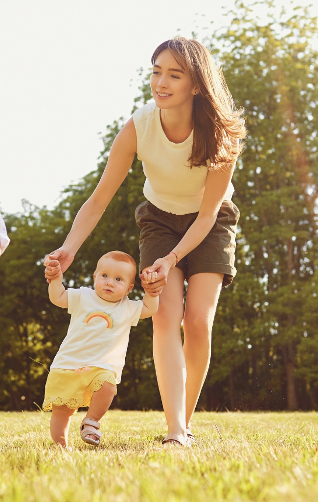 Nanny and baby walking in a park
